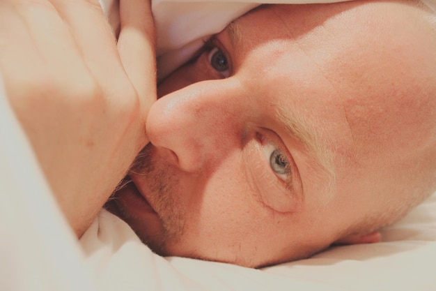 写真 ベッドでリラックスしている男性のクローズアップ肖像画