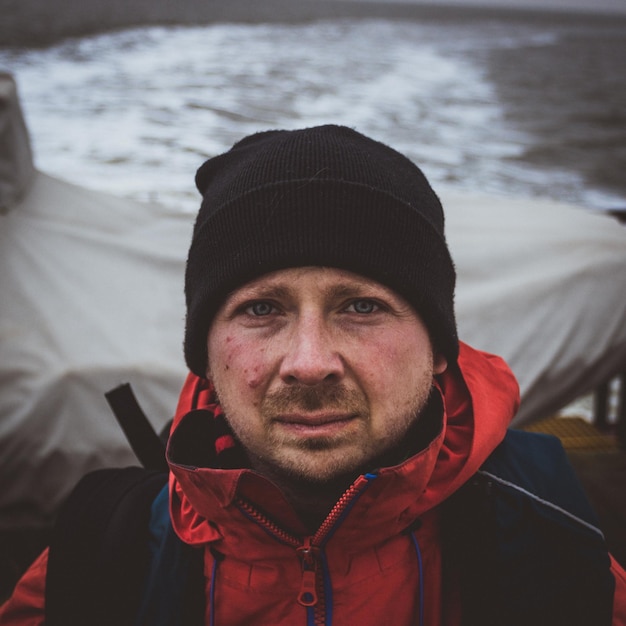 Фото Портрет мужчины в вязаной шляпе на лодке в море