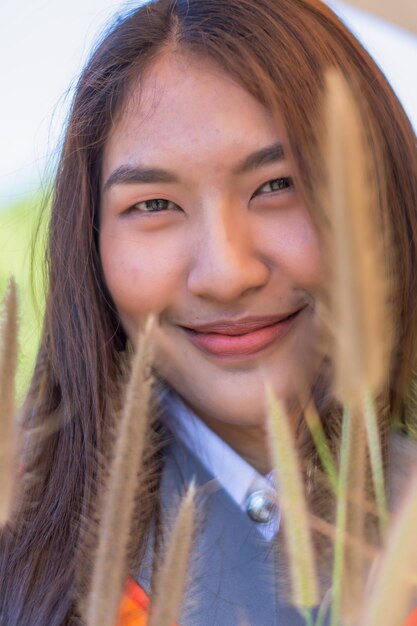 写真 植物の近くで笑顔の若い女性のクローズアップ肖像画