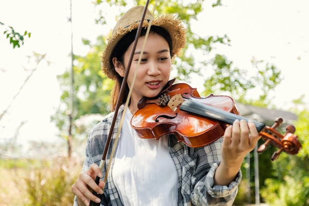 Фото Макро портрет молодой азиатской женщины скрипач играть на скрипке, расслабиться в саду с душевным спокойствием.