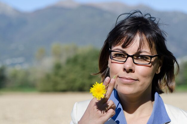 写真 花を持った若い女性のクローズアップ肖像画