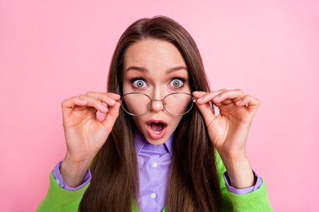 Close-up portrait of pretty amazed worried long-haired girl nerd geek scientist touching specs news reaction isolated on pink pastel color background