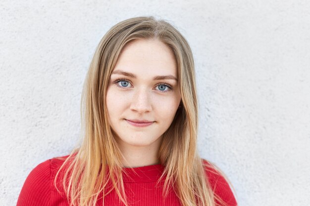 Close up portrait of pretty blonde woman with blue alluring eyes