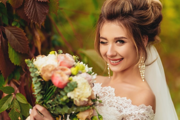 Close up portrait of a pretty bride winking in autumn park