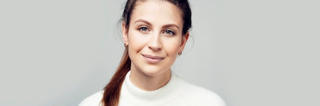 Close up portrait of a pretty brunette woman smiling with a pigtail of