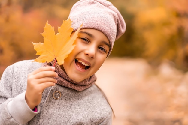 Close-up portrait of pretty little girl resting in autumnal park