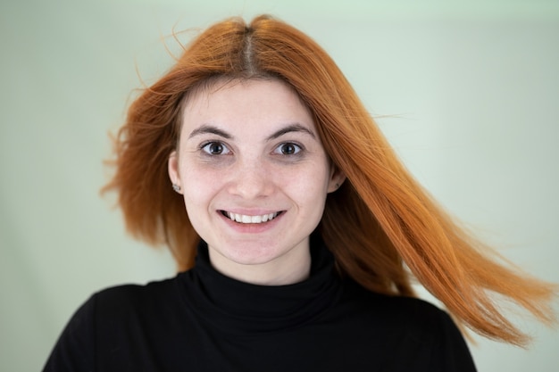 Close up portrait of pretty redhead woman with long wavy hair