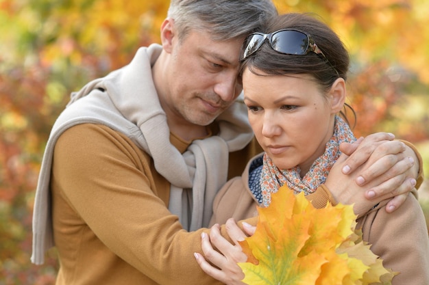 Close up portrait of sad couple posing in autumnal park