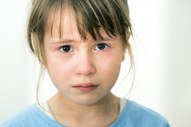 Chiuda sul ritratto della ragazza gridante triste del bambino