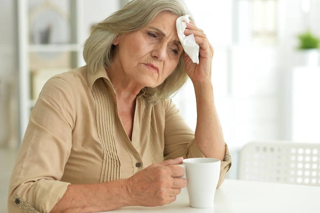 Close up portrait of sad ill senior woman posing at home