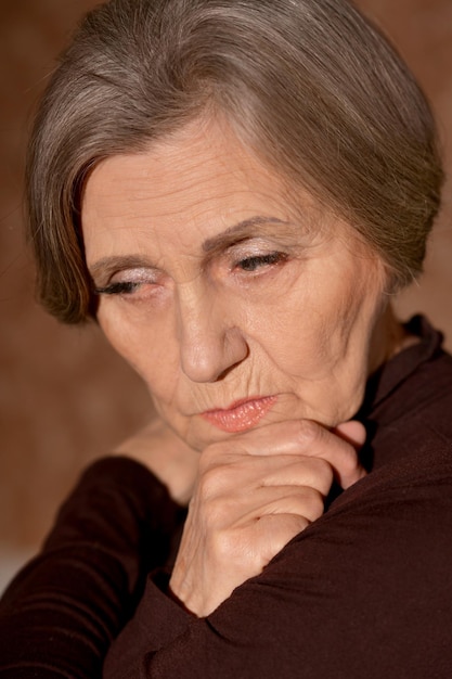 Close up portrait of sad senior woman at home