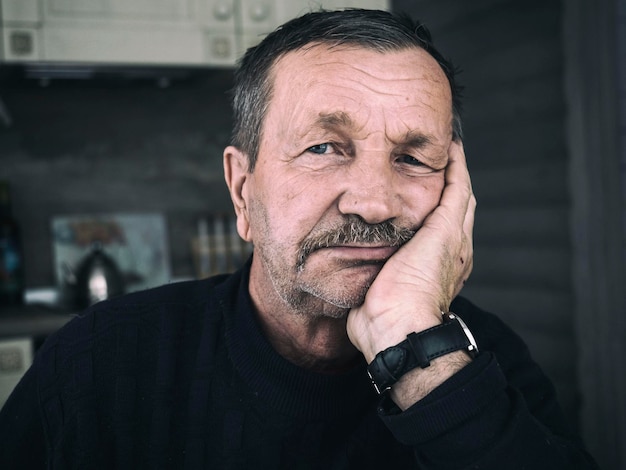 Close-up portrait of senior man sitting at home