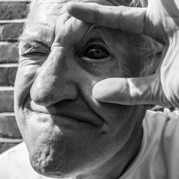 Foto ritratto ravvicinato di un uomo anziano con l'occhio iniettato di sangue