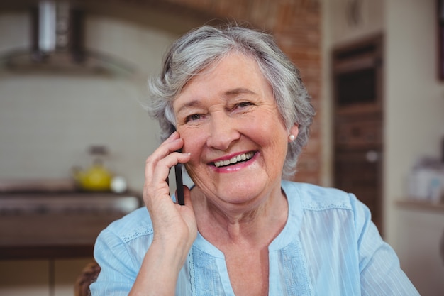 Close-up portrait of senior woman talking on mobile phone 