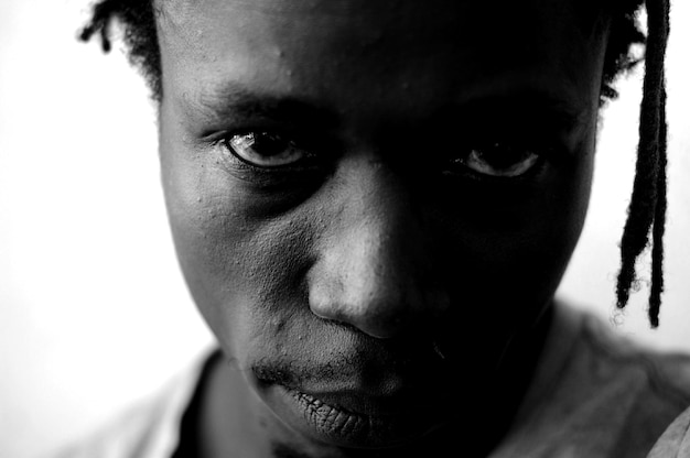 Close-up portrait of serious man against white background
