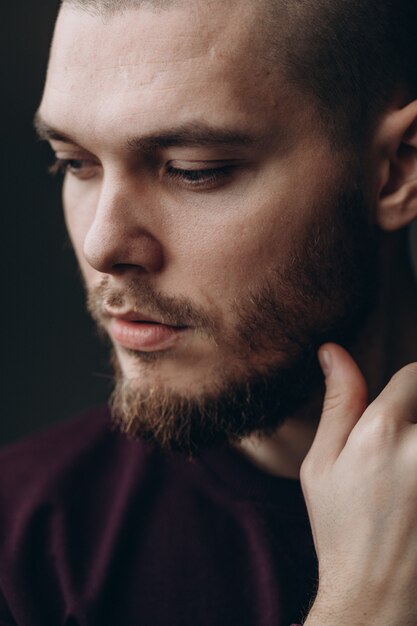 Foto ritratto del primo piano di un giovane serio che distoglie lo sguardo sul gray