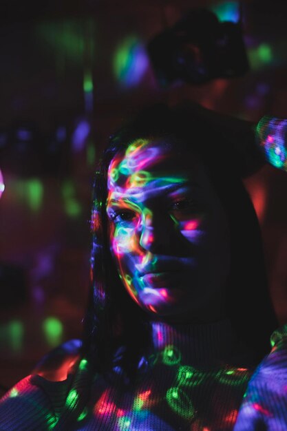 Close-up portrait of serious young woman in illuminated room at night