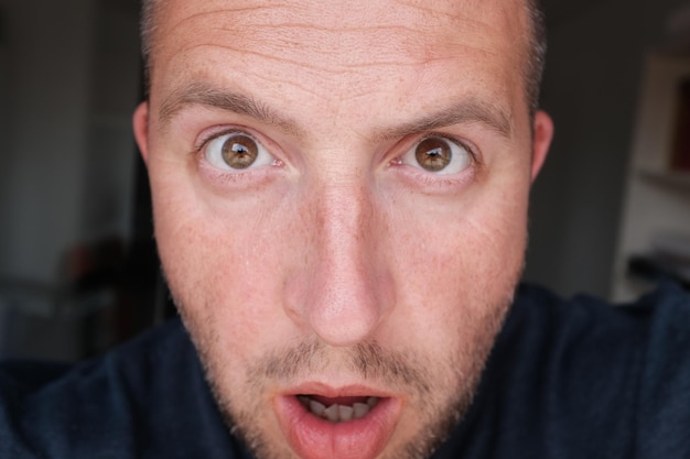 Photo close-up portrait of shocked man at home