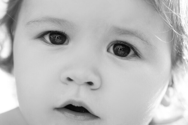 Close up portrait of a small blond baby boy cropped face Funny kids face