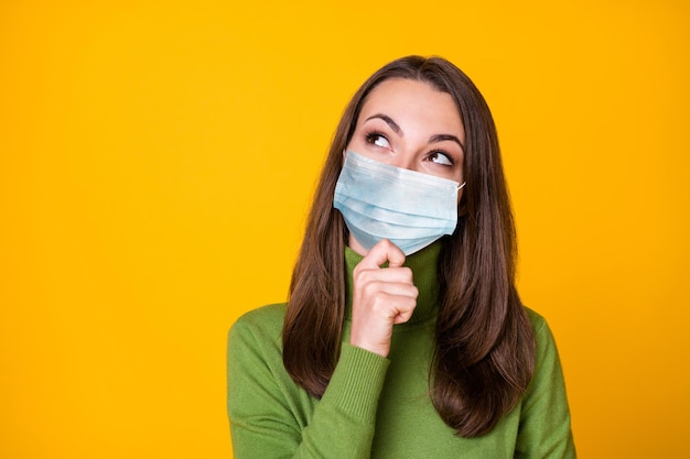 Close-up portrait of smart girl creating new solution wearing blue face mask isolated on vivid yellow color background