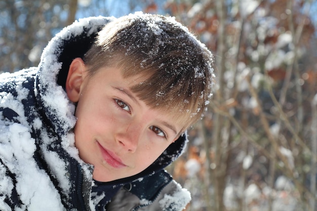 雪の中の笑顔の男の子のクローズアップ肖像画