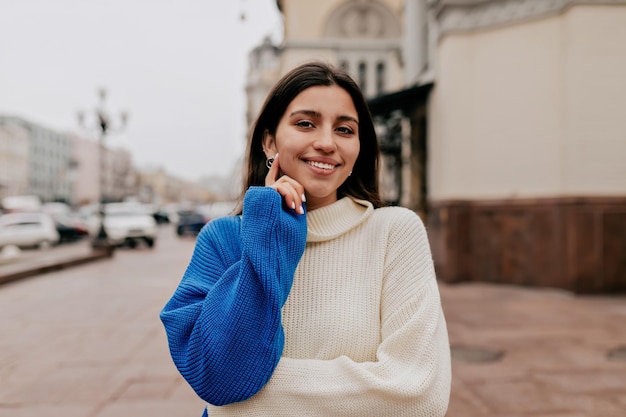 Close up portrait of smiling european woman with dark hair and wonderful smile is looking at camera