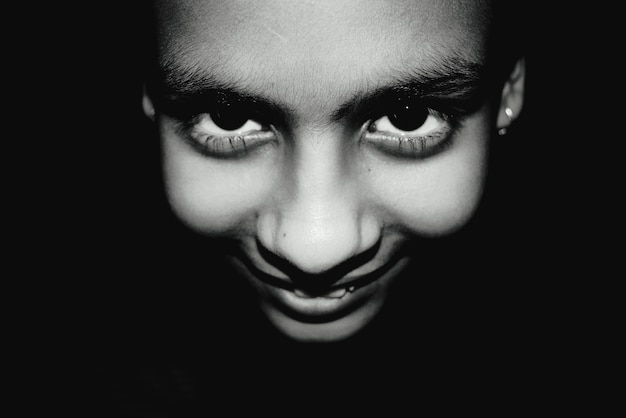 Photo close-up portrait of smiling girl in darkroom