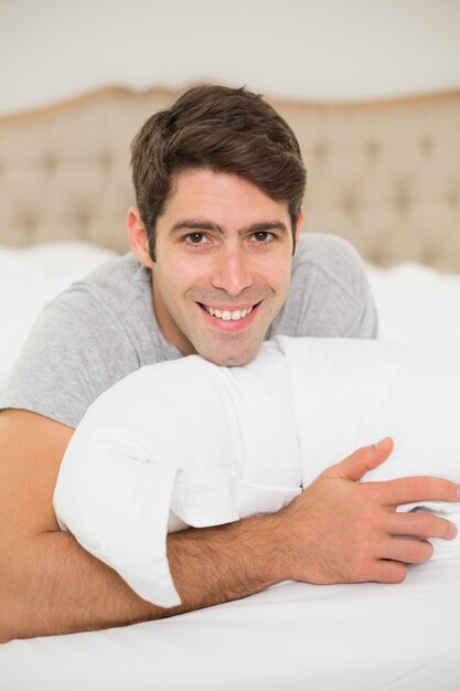 Foto chiuda sul ritratto di un uomo sorridente che riposa a letto