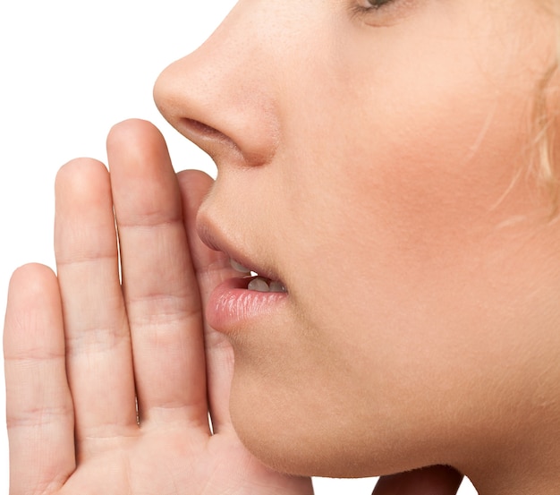 Close up portrait of a smiling skin care woman whispers (tells) a gossip.