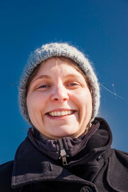 Close-up portrait of smiling woman wearing knit hat during winter