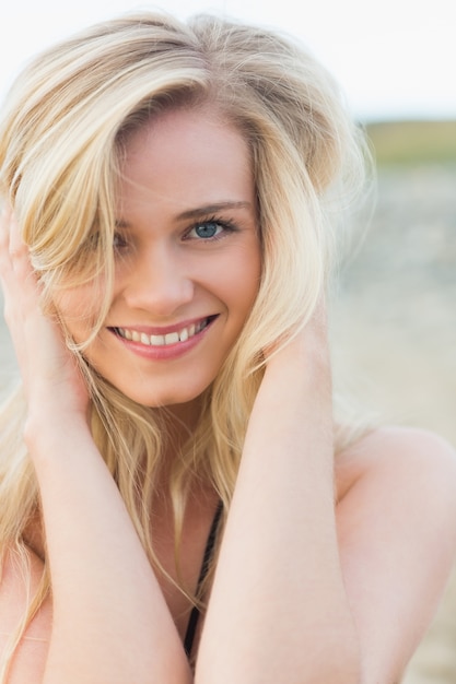 Крупным планом портрет улыбающегося блондинка на пляже