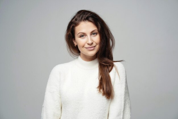 Close up portrait of a smiling young brunette woman of\
caucasian appearance looking