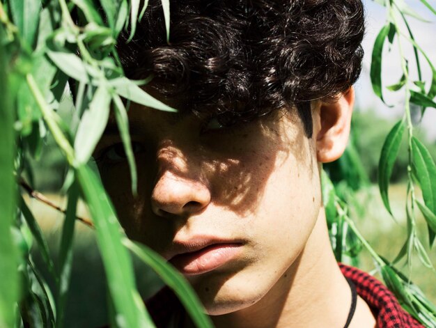 Photo close-up portrait of smiling young man by leaves