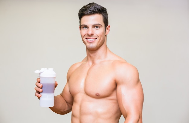 Close-up portrait of a sporty young man with protein drink