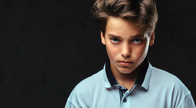 Close-up portrait of a stylish teenager dressed in a white t-shirt. Isolated on a dark background.