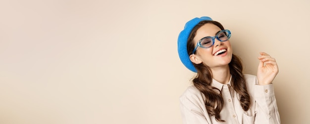 Foto ritratto ravvicinato di donna alla moda che posa in occhiali da sole ridendo e sorridendo indossando abiti alla moda s