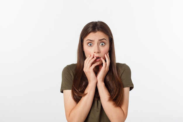 Close-up portrait of surprised beautiful woman holding her head in amazement and open-mouthed.