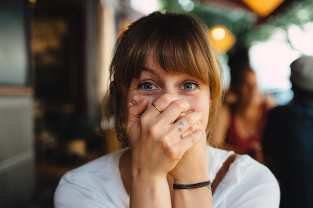 Foto ritratto da vicino di una donna sorpresa con le mani che coprono la bocca