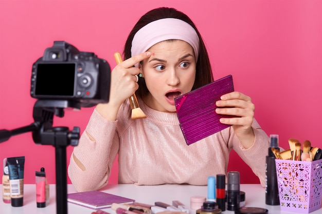 Foto chiuda sul ritratto del vlogger sorpreso di bellezza della giovane donna