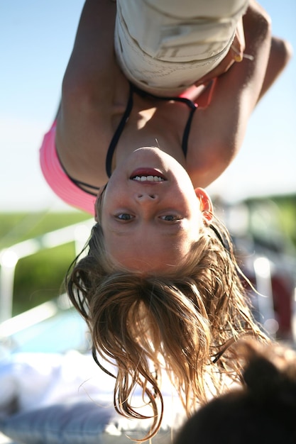 Photo close-up portrait of teenage girl hanging upside down at playground