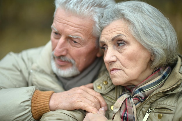 Close-up portrait of thoughtful senior couple outdoors