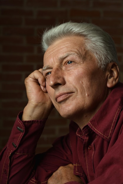 Close up portrait of thoughtful senior man at home