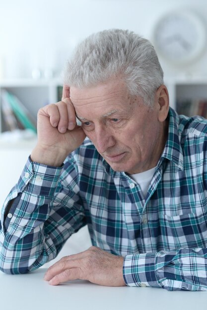 Close up portrait of thoughtful senior man at home