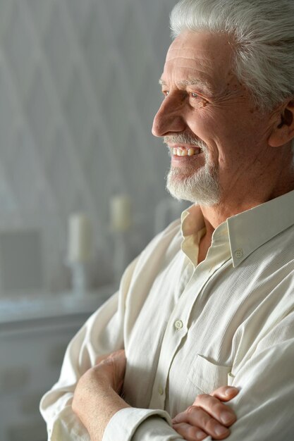 Close up portrait of thoughtful senior man at home