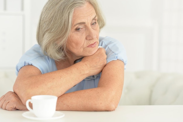 Close up portrait of tired senior woman at home