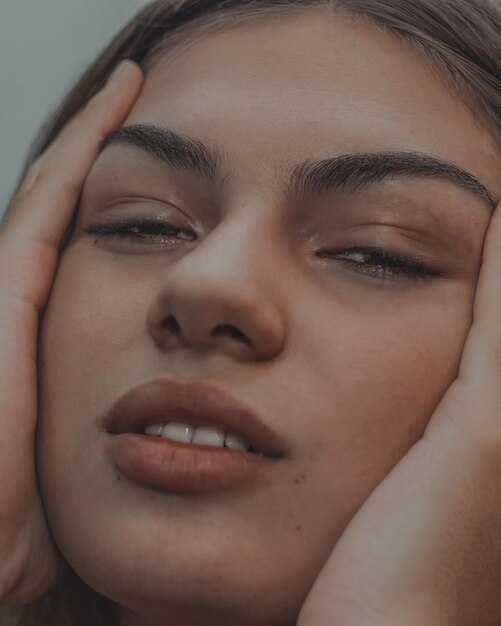 Photo close-up portrait of tired young woman with hand on chin