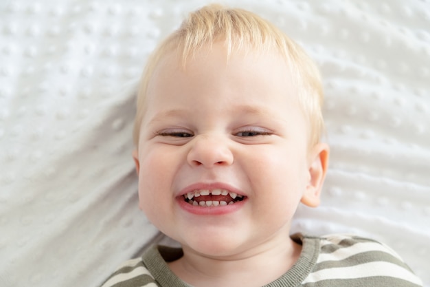 齲蝕の歯で笑っている肖像画の幼児の男の子を閉じます。