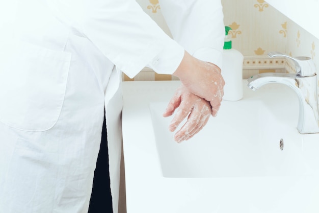 Close up portrait of washing hands in the bathroom to prevent virus transmission