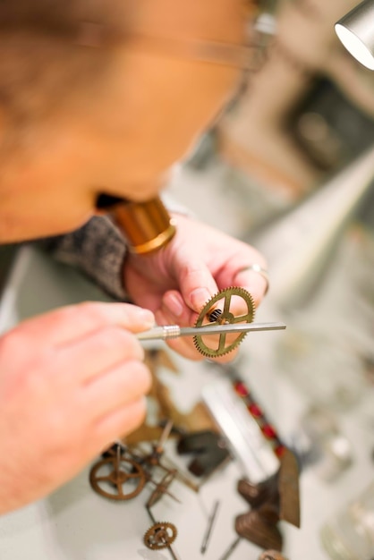 Foto close up ritratto di un orologiaio al lavoro