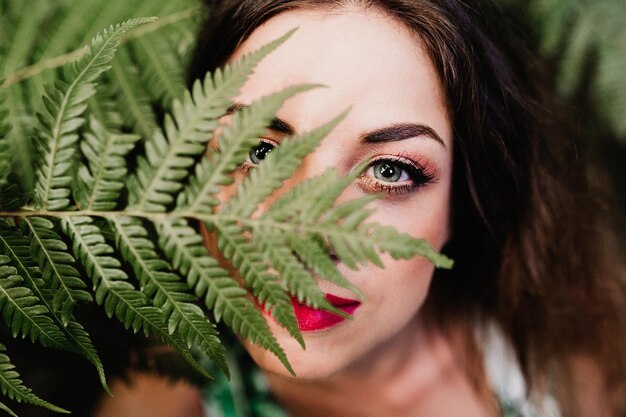 Foto ritratto di una donna da vicino con foglie verdi